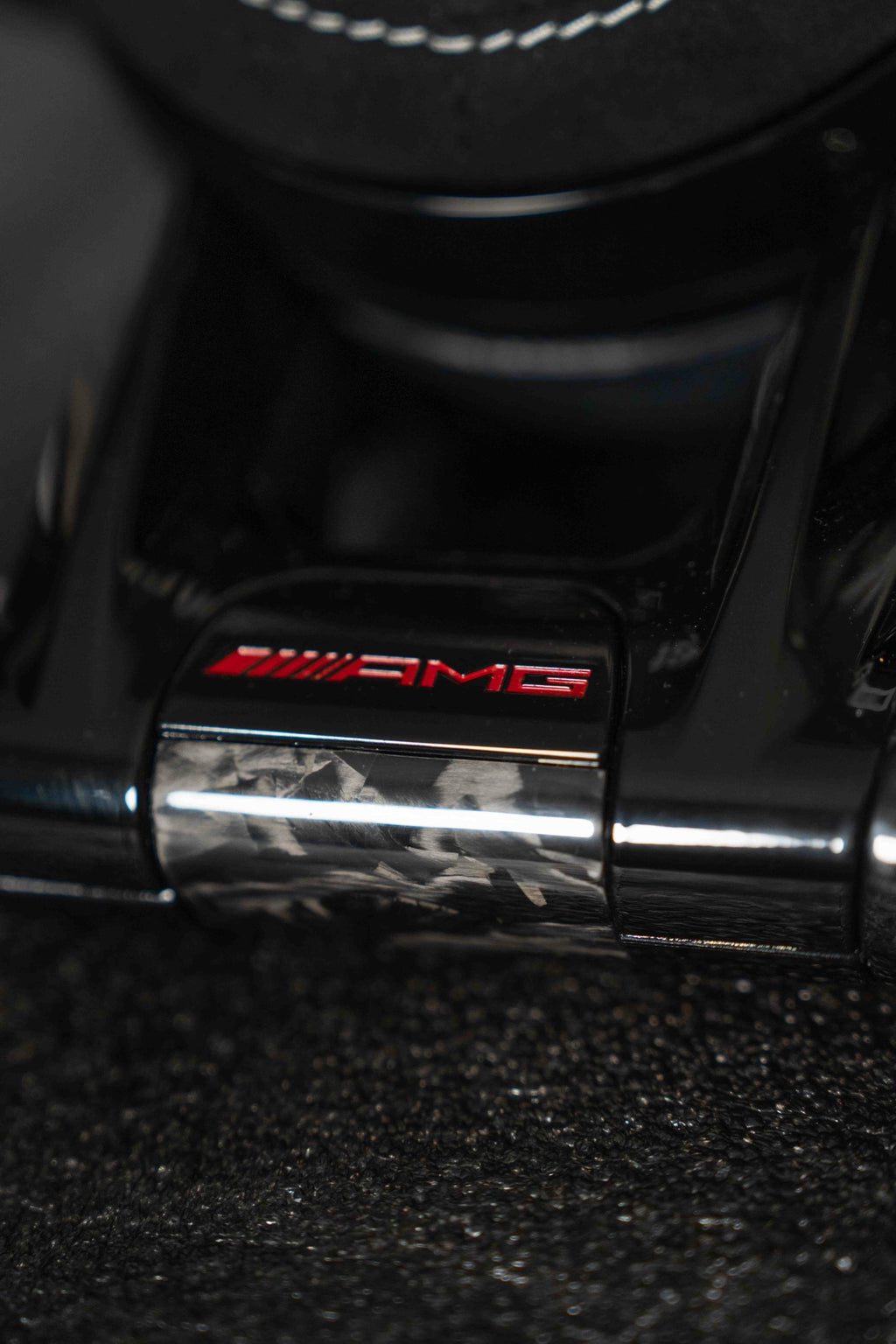 Emblema AMG en rojo sobre embellecedor inferior de carbono forjado
