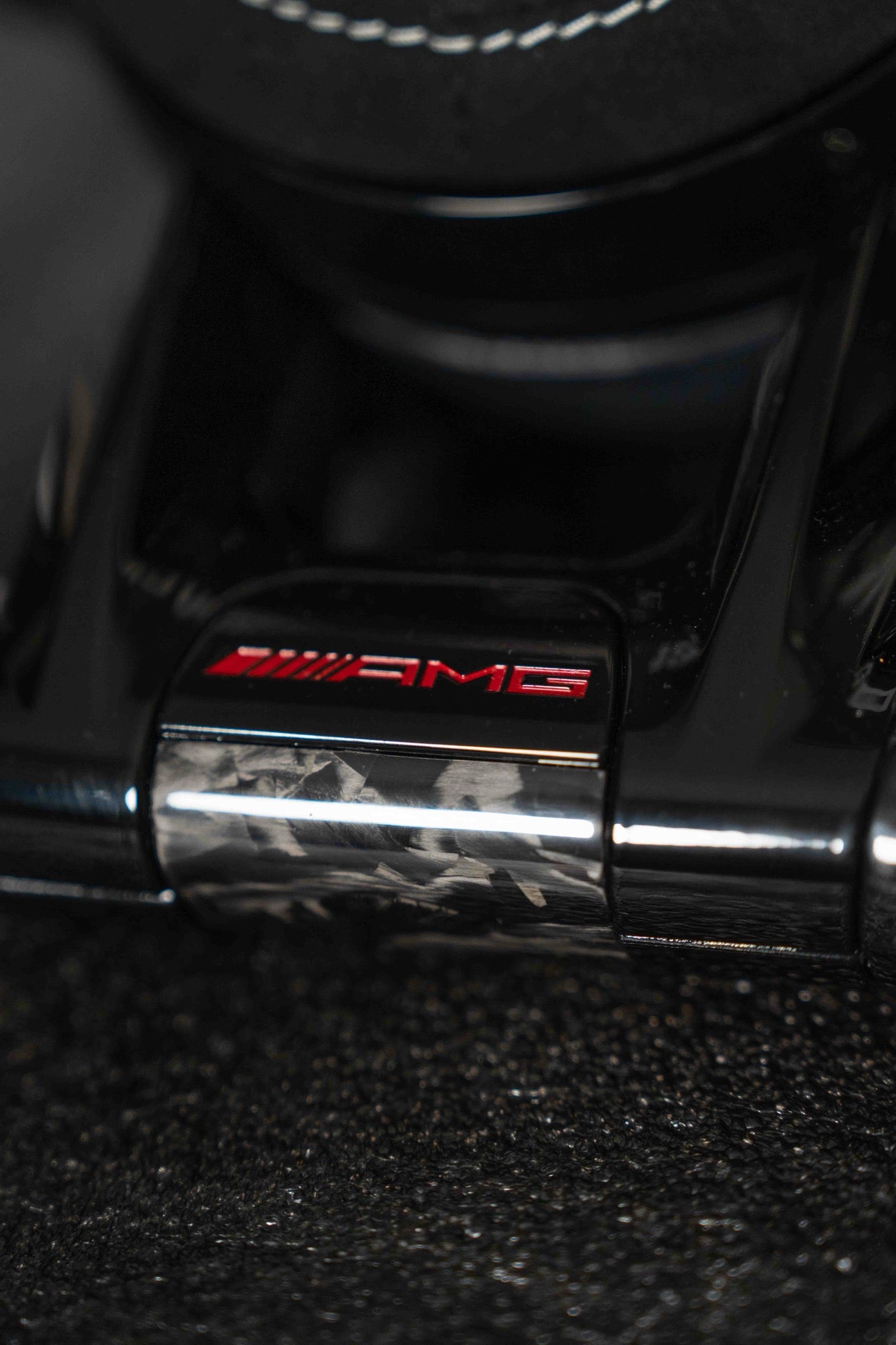 Emblema AMG en rojo sobre embellecedor inferior de carbono forjado