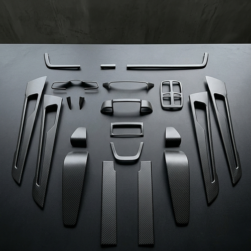 Kit interior de 19 piezas en fibra de carbono con acabado mate para Porsche Panamera 2025 dispuesto sobre mesa negra
