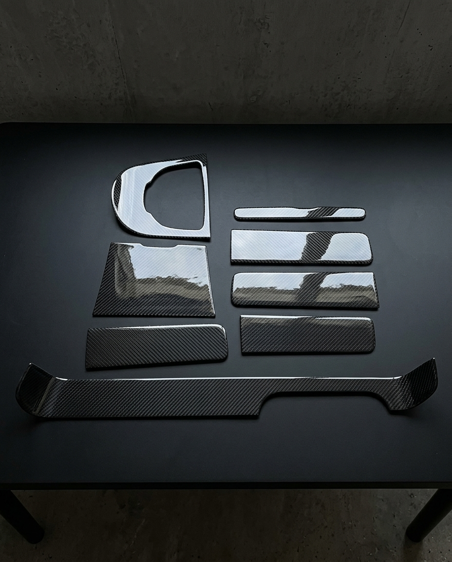 Kit interior de fibra de carbono de 8 piezas para Mercedes Clase G W463 y W464 dispuesto sobre mesa negra