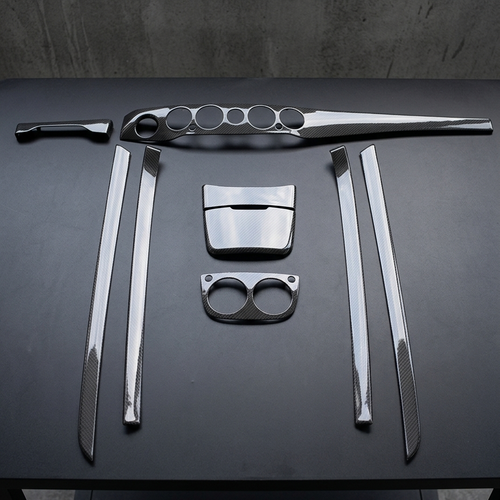 Kit interior de fibra de carbono de 9 piezas para Mercedes Clase S W222 dispuesto sobre mesa negra