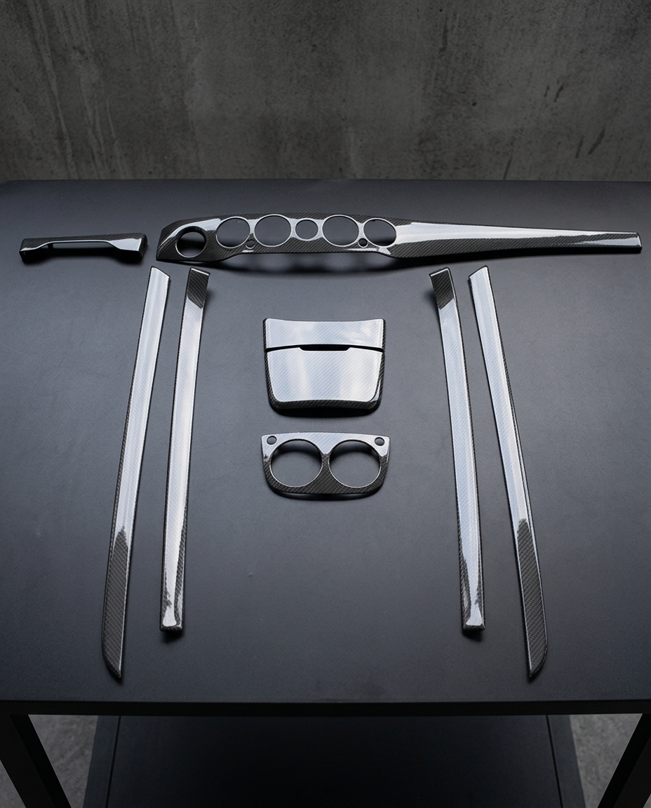 Kit interior de fibra de carbono de 9 piezas para Mercedes Clase S W222 dispuesto sobre mesa negra