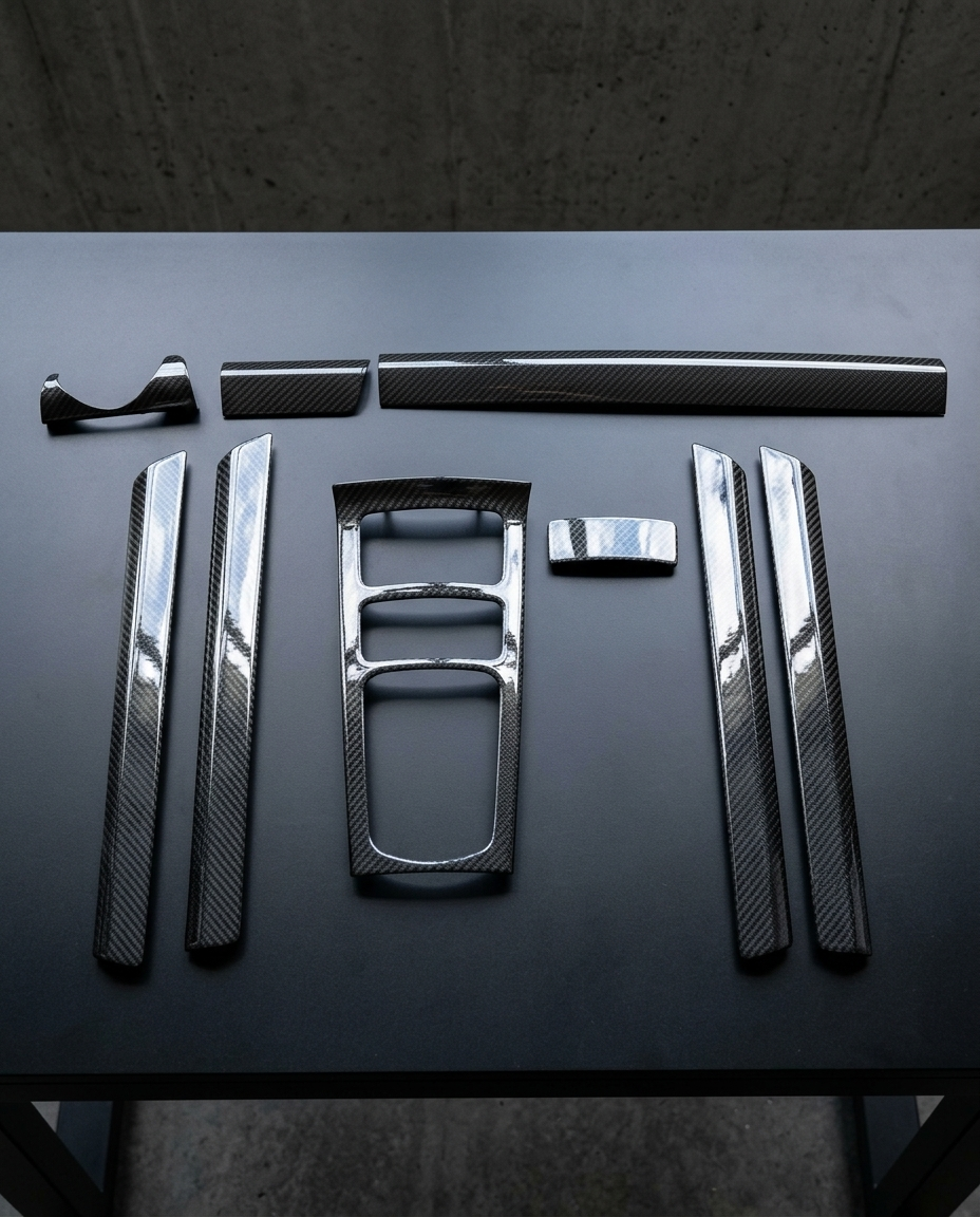 Kit interior de carbono seco de 9 piezas para Porsche Cayenne 958 dispuesto sobre mesa negra